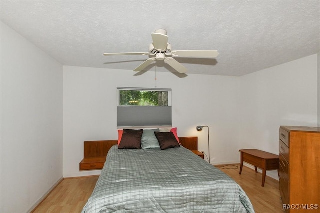 bedroom featuring a textured ceiling, ceiling fan, and light hardwood / wood-style floors