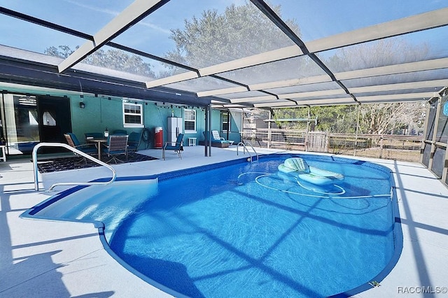 view of swimming pool featuring a patio area and glass enclosure