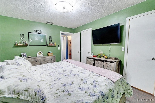 bedroom with hardwood / wood-style flooring and a textured ceiling