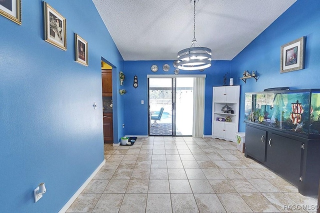 interior space with light tile patterned floors, a notable chandelier, and a textured ceiling