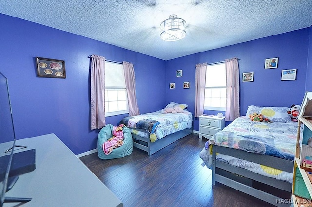 bedroom with a textured ceiling and dark hardwood / wood-style flooring