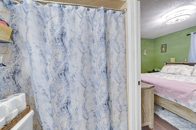 bedroom with hardwood / wood-style floors and a textured ceiling