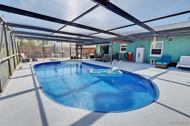 view of pool with a patio and glass enclosure