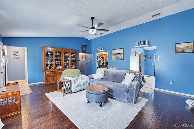 living room featuring ceiling fan, lofted ceiling, dark hardwood / wood-style flooring, and a textured ceiling