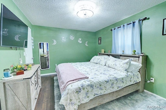 bedroom featuring dark hardwood / wood-style floors and a textured ceiling