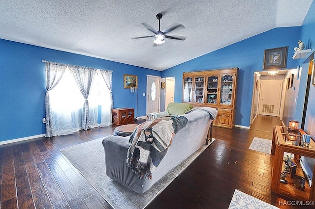 living room with dark wood-type flooring, ceiling fan, lofted ceiling, and a textured ceiling