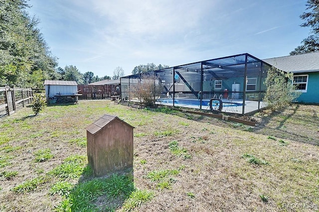 view of yard with a fenced in pool, a lanai, and a storage unit