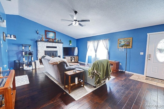 living room featuring wood-type flooring, lofted ceiling, ceiling fan, and a fireplace