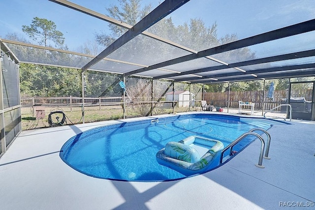 view of pool with a patio, glass enclosure, and a shed