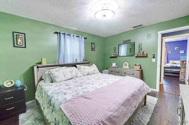 bedroom featuring dark hardwood / wood-style floors and a textured ceiling