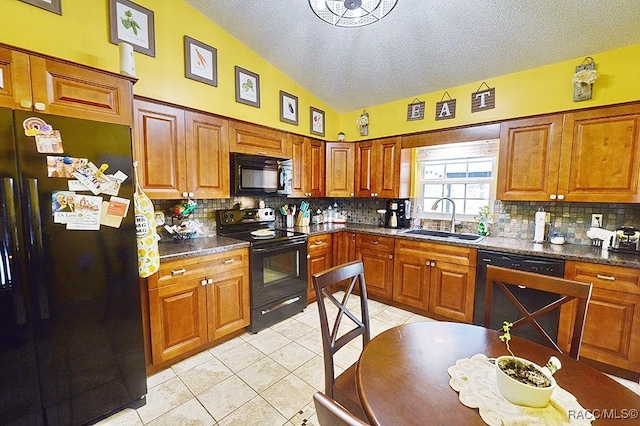 kitchen featuring lofted ceiling, sink, light tile patterned floors, backsplash, and black appliances