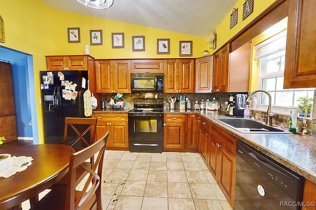 kitchen featuring sink, black appliances, vaulted ceiling, light tile patterned floors, and backsplash