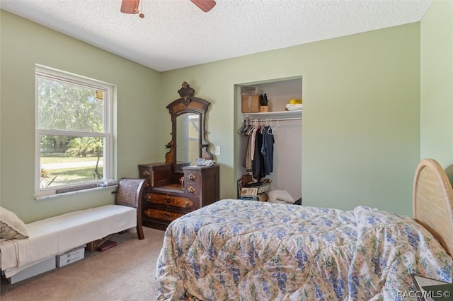 carpeted bedroom featuring ceiling fan, a textured ceiling, and a closet