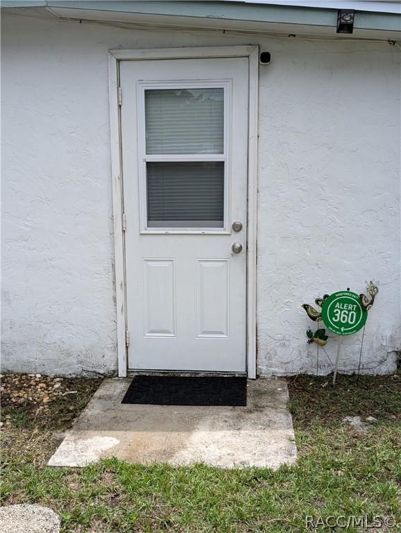 view of exterior entry with stucco siding