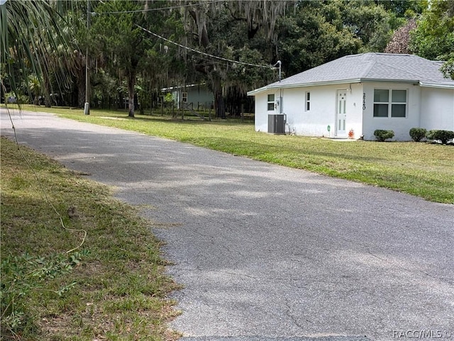 view of front of house with cooling unit and a front yard