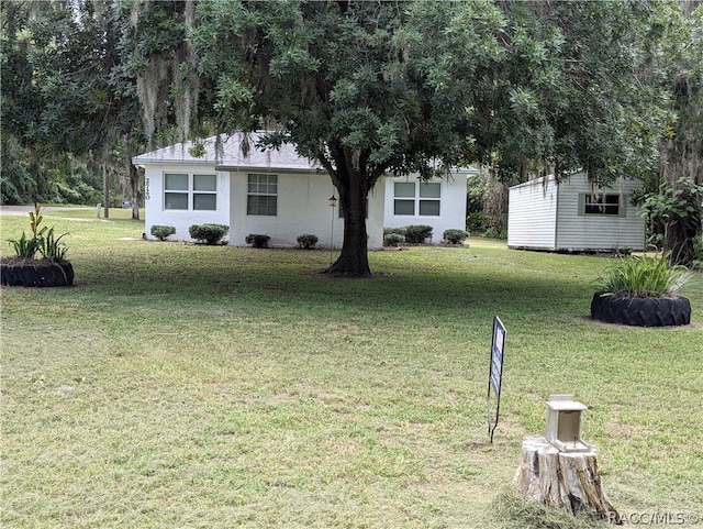 view of front of house with an outdoor structure and a front yard