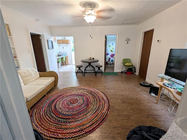 living area featuring a textured ceiling, wood finished floors, and visible vents