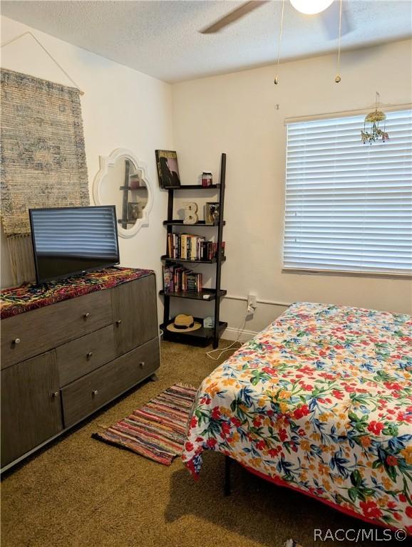 bedroom featuring carpet floors, baseboards, a ceiling fan, and a textured ceiling