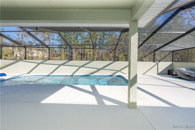 view of swimming pool featuring a lanai and a patio