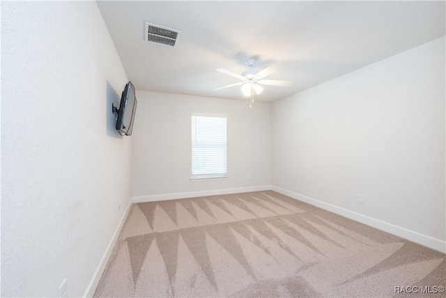 carpeted spare room with ceiling fan