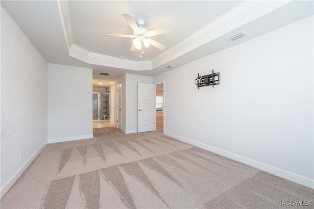 unfurnished bedroom with a raised ceiling, ceiling fan, crown molding, and light colored carpet