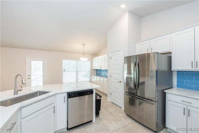 kitchen featuring sink, stainless steel appliances, tasteful backsplash, vaulted ceiling, and white cabinets