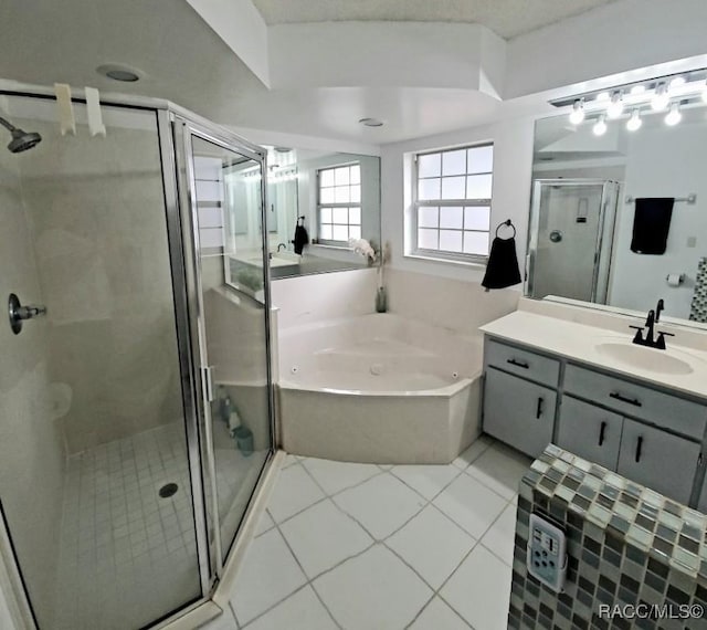 bathroom with tile patterned floors, vanity, and shower with separate bathtub