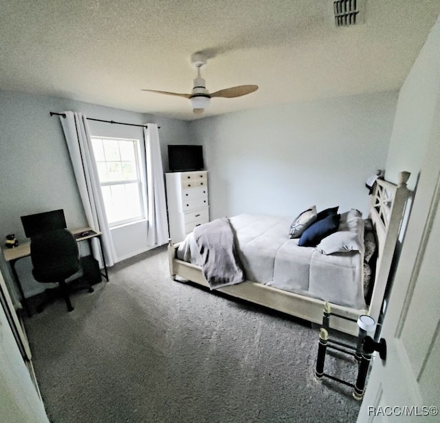 carpeted bedroom featuring ceiling fan and a textured ceiling