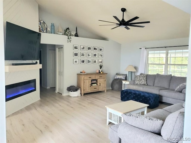 living room featuring ceiling fan, lofted ceiling, and light wood-type flooring