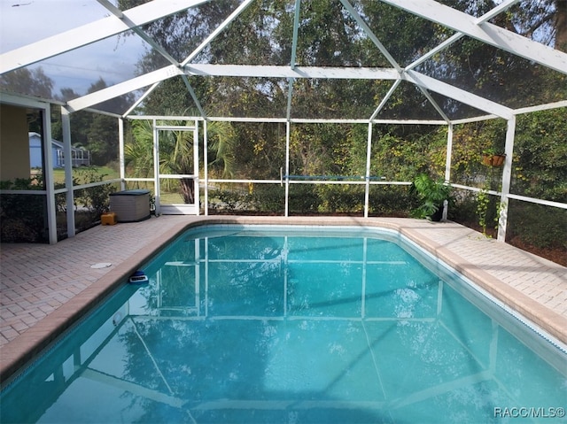 view of swimming pool with a lanai and a patio