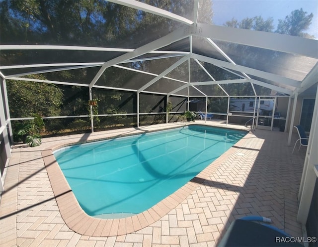 view of pool featuring a patio area and glass enclosure