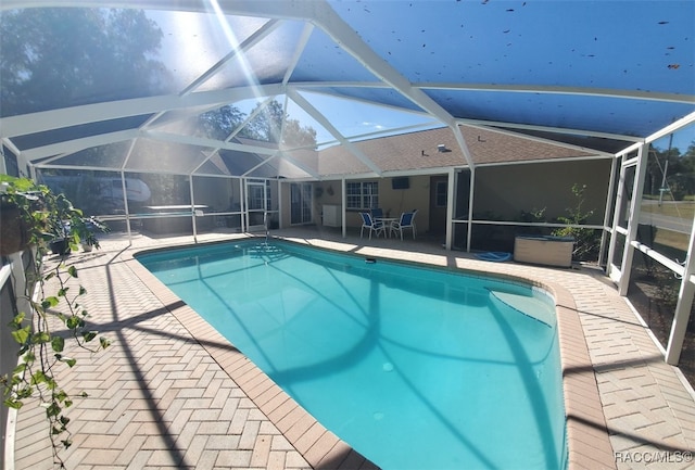 view of swimming pool with a patio area and glass enclosure