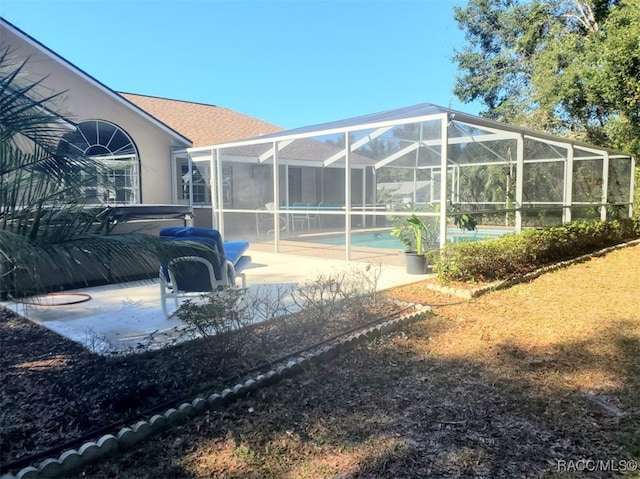 rear view of property with a lanai and a patio area