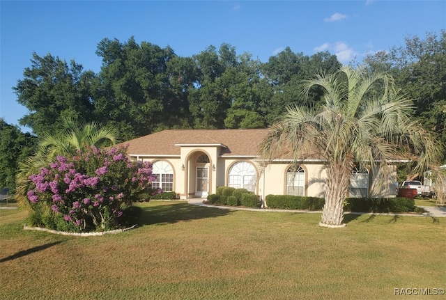 mediterranean / spanish-style home featuring a front yard