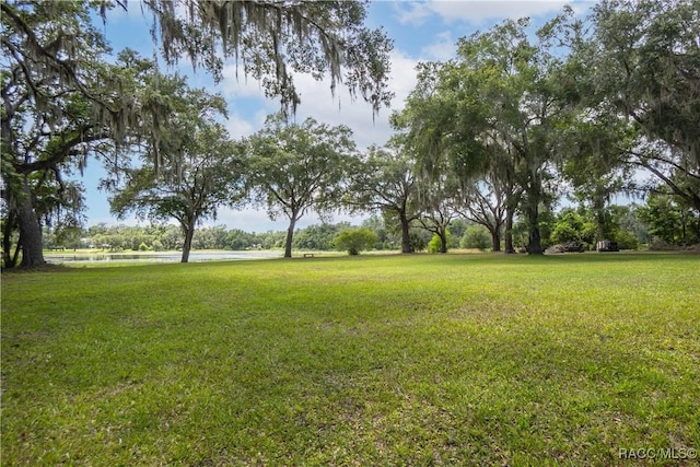 9093 E Pinehurst Ct, Inverness, FL 34450 - view of green lawn featuring a water view