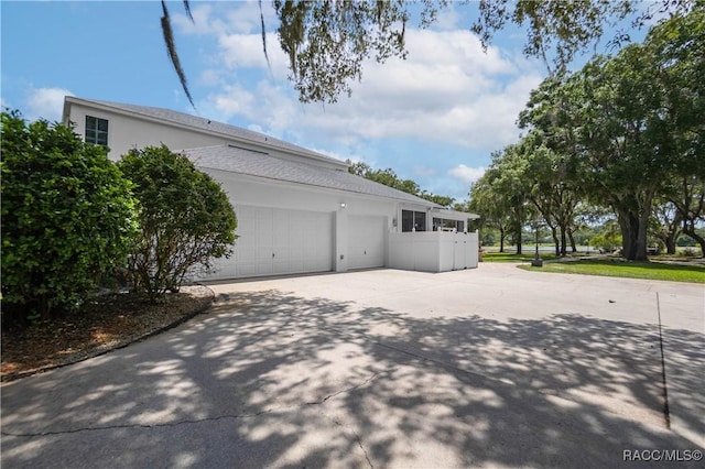 9093 E Pinehurst Ct, Inverness, FL 34450 - view of home's exterior featuring driveway, stucco siding, and an attached garage