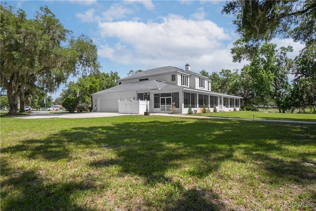 9093 E Pinehurst Ct, Inverness, FL 34450 - view of front facade with a sunroom, driveway, a front lawn, an attached garage, and a chimney