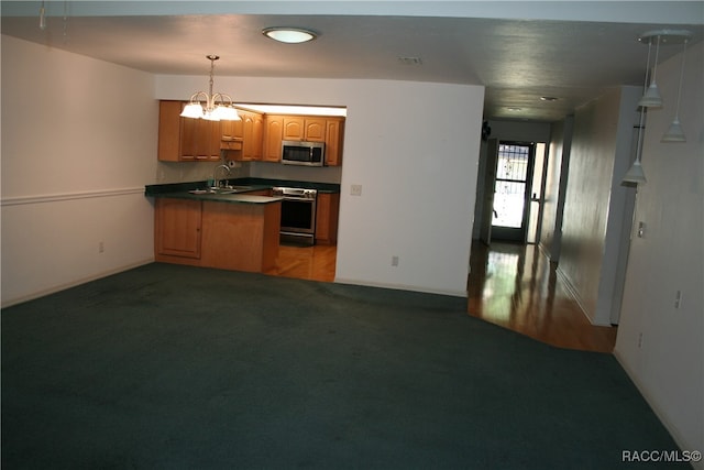 kitchen with sink, stainless steel appliances, kitchen peninsula, pendant lighting, and carpet