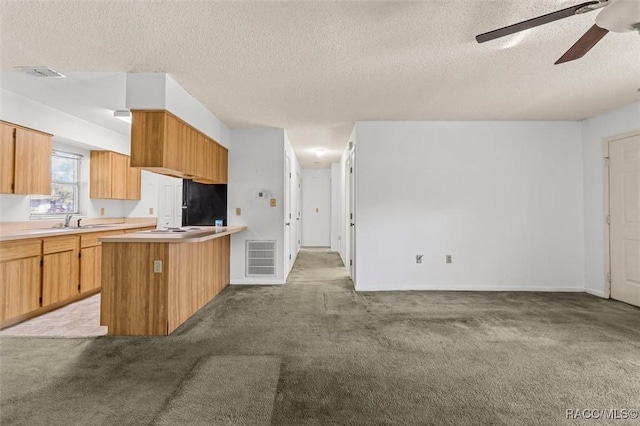 813 Constitution Blvd, Inverness, FL 34453 - kitchen featuring a peninsula, visible vents, light colored carpet, and a ceiling fan
