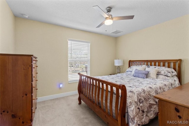 carpeted bedroom featuring a textured ceiling and ceiling fan