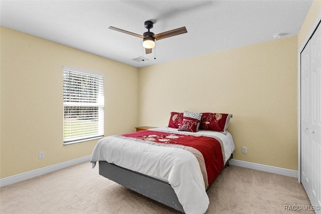 carpeted bedroom featuring ceiling fan and a closet