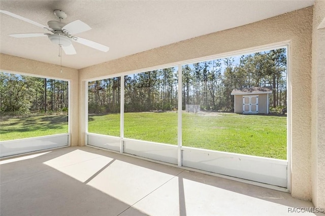 unfurnished sunroom featuring ceiling fan and a healthy amount of sunlight