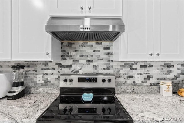 kitchen featuring electric stove, light stone counters, ventilation hood, white cabinets, and decorative backsplash