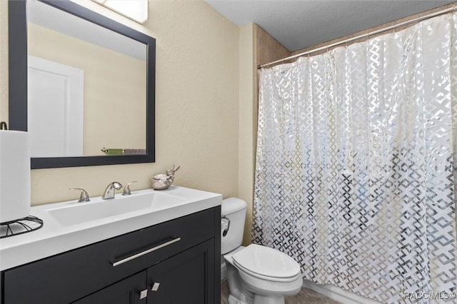 bathroom featuring toilet, a textured ceiling, vanity, and walk in shower