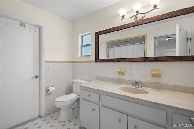 bathroom featuring vanity, toilet, and tile walls