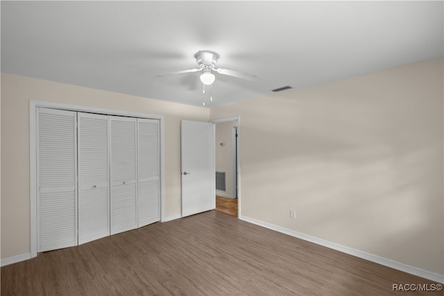 unfurnished bedroom with hardwood / wood-style floors, a closet, and ceiling fan