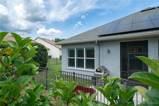 view of home's exterior with a yard and solar panels