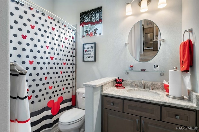 bathroom featuring vanity, toilet, and walk in shower