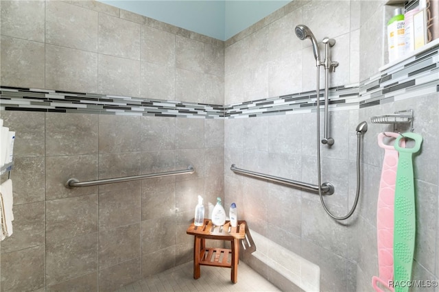 bathroom featuring a tile shower and tile walls