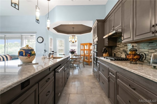 kitchen featuring plenty of natural light, dark brown cabinetry, hanging light fixtures, and stainless steel appliances